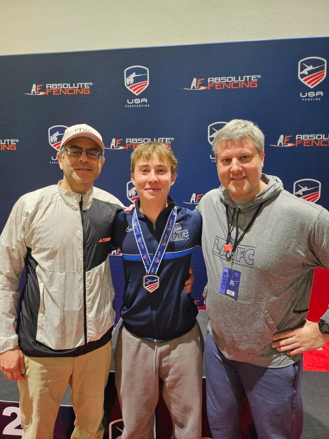 Adrian Erlikhman on the podium with a USA Fencing medal